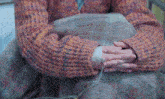 a woman in a colorful sweater has an iv in her arm