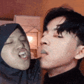 a man and a woman making funny faces with their eyes closed
