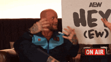 a man holding a sign that says hey ew