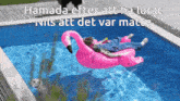 a man is laying on a pink flamingo in a swimming pool
