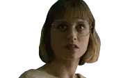 a woman wearing glasses and a white sweater looks at the camera