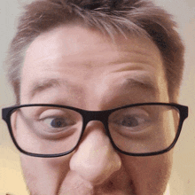 a man wearing glasses makes a funny face