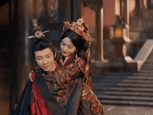 a man is carrying a woman on his back in a costume