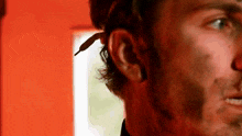 a close up of a man 's head with a red background