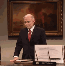 a man in a suit and tie is standing in front of a box that says bankers box