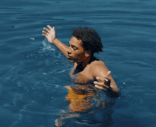 a shirtless man is swimming in the water