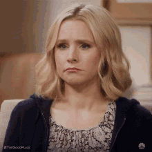 a woman is making a sad face while sitting on a couch .