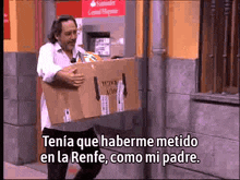 a man is carrying a cardboard box with the words tenia que haberme metido en la renfe