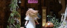 a woman in a white dress is running in front of a building