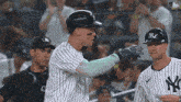 two new york yankees baseball players are talking to each other in front of a crowd