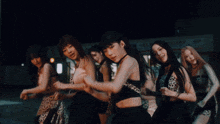 a group of women are dancing in front of a store called lee 's deli grocery