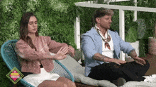 a man and a woman are sitting on a chair with a sign that says ' a record ' on it