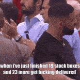 a man with a beard is standing in a crowd of people and talking to someone .