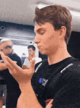 a man wearing a black shirt with the word gulf on it is making a funny face .