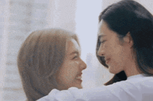 two women are looking at each other with their eyes closed