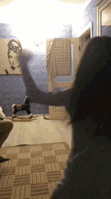 a woman is playing with a rocking horse in a room .