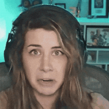 a woman wearing headphones looks at the camera