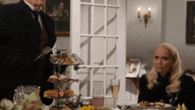 a woman sits at a table with a tray of food on it