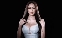 the woman is wearing a white dress with a plunging neckline and a tattoo on her arm .