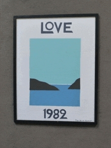 a framed poster that says love 1982 is hanging on a wall