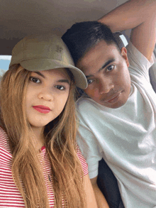 a man and a woman pose for a picture in a car