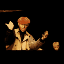 a man with red hair is giving a thumbs up while standing next to another man in a tiger sweater .