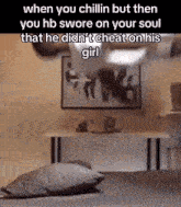 a person is sitting on a bed in a room with a painting on the wall .