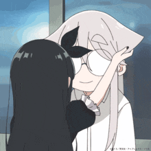 a cartoon drawing of a girl touching another girl 's face with chinese writing on the bottom