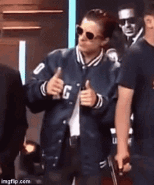 a woman in a blue jacket is giving a thumbs up .