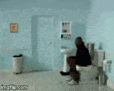 a man is jumping in the air while sitting on a toilet in a bathroom .