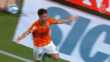 a soccer player wearing an orange shirt with the word ora on it