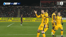a group of soccer players on a field with ads for doppio malto behind them