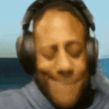 a blurry picture of a man wearing headphones and making a face