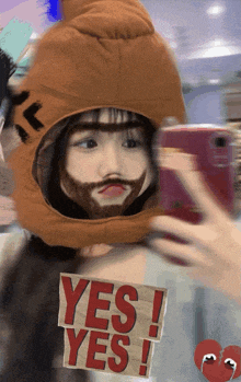 a girl with a beard is taking a selfie with a sign that says yes