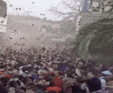 a crowd of people are gathered in front of a building with confetti falling
