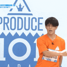 a man stands in front of a produce 101 sign