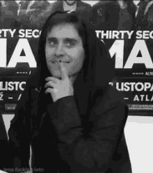 a black and white photo of a man standing in front of a sign that says thirty sec 1a