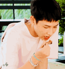 a man in a white shirt is eating a piece of food with the letters ap on the bottom