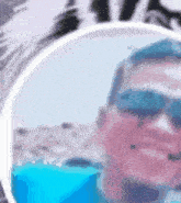 a man wearing sunglasses and a blue shirt is taking a selfie .