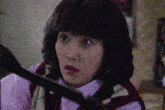 a woman with a surprised look on her face is wearing a sweater vest