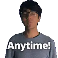 a man wearing glasses and a grey shirt with the words anytime written on it