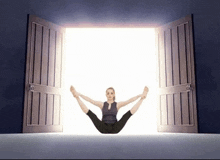 a woman is doing a yoga pose in an open doorway .