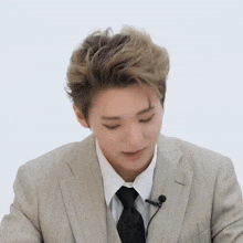 a man in a suit and tie has a microphone attached to his jacket