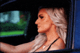 a woman is sitting in a car and looking out the window