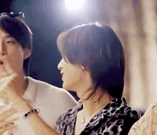 a woman wearing a leopard print shirt is talking to a man wearing a white shirt