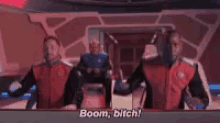 a group of men are standing in a room and one of them is talking .