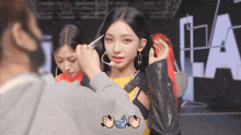 a woman is getting her hair done by a man in front of a sign that says la