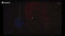 a person 's hand is visible in a dark room behind a screen .