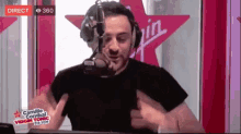 a man wearing headphones is talking into a microphone in front of a virgin logo ..