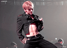 a man in a black suit is dancing on a stage with a watermark that says cn.han.b.yvs